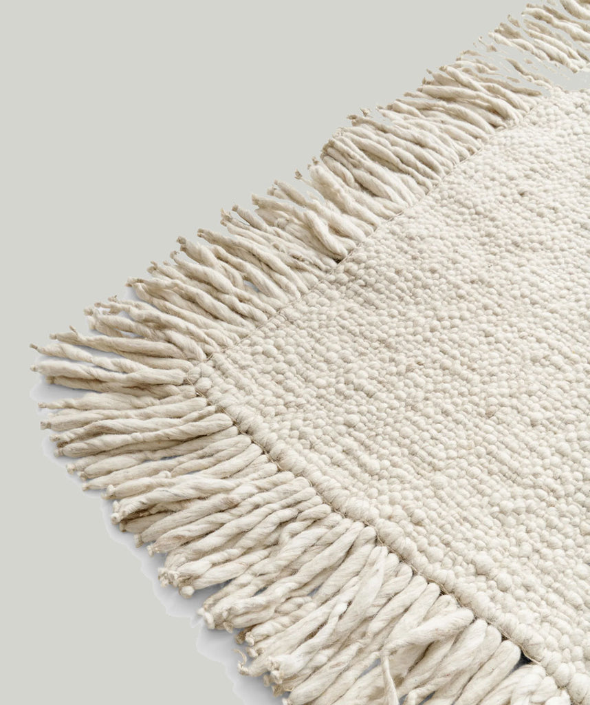 No 12 comes in a creamy natural ivory white, made from unbleached New Zeeland wool. This elevated yet simple piece is more classic in appearance than the rest of the Cappelen Dimyr collection, while still capturing the essence of its DNA: conscious, crafted, and personal.